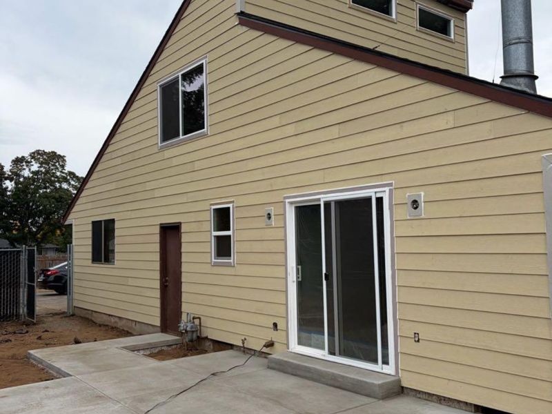 Home exterior with new siding and concrete patio